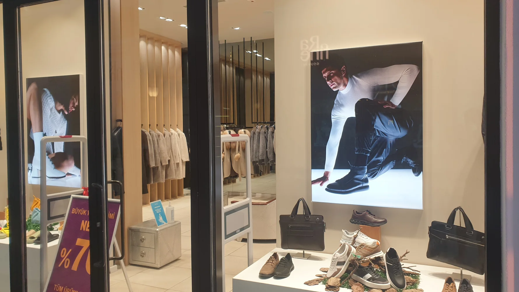 Two illuminated pictures in the window of a shoe shop