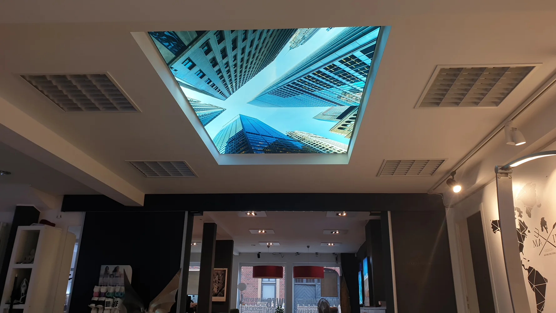Illuminated ceiling with a high-rise image above the sales area